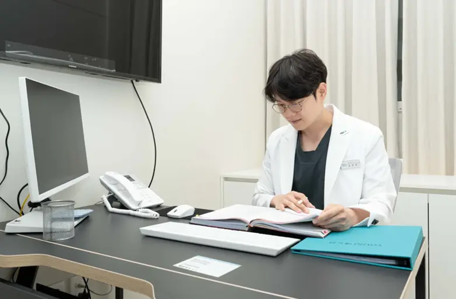 유앤아이의원 안양점 의료진이 진료실에서 의학 자료를 검토하는 모습