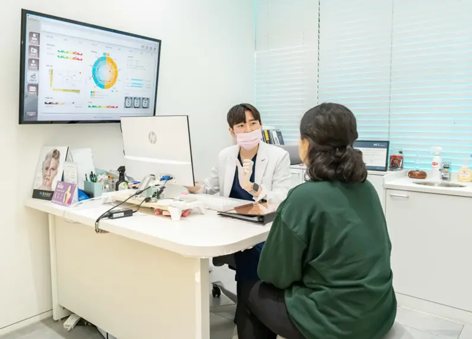 마곡 피부과 진료실에서 의료진이 환자에게 피부 상태와 색소 치료 계획을 상담하는 모습