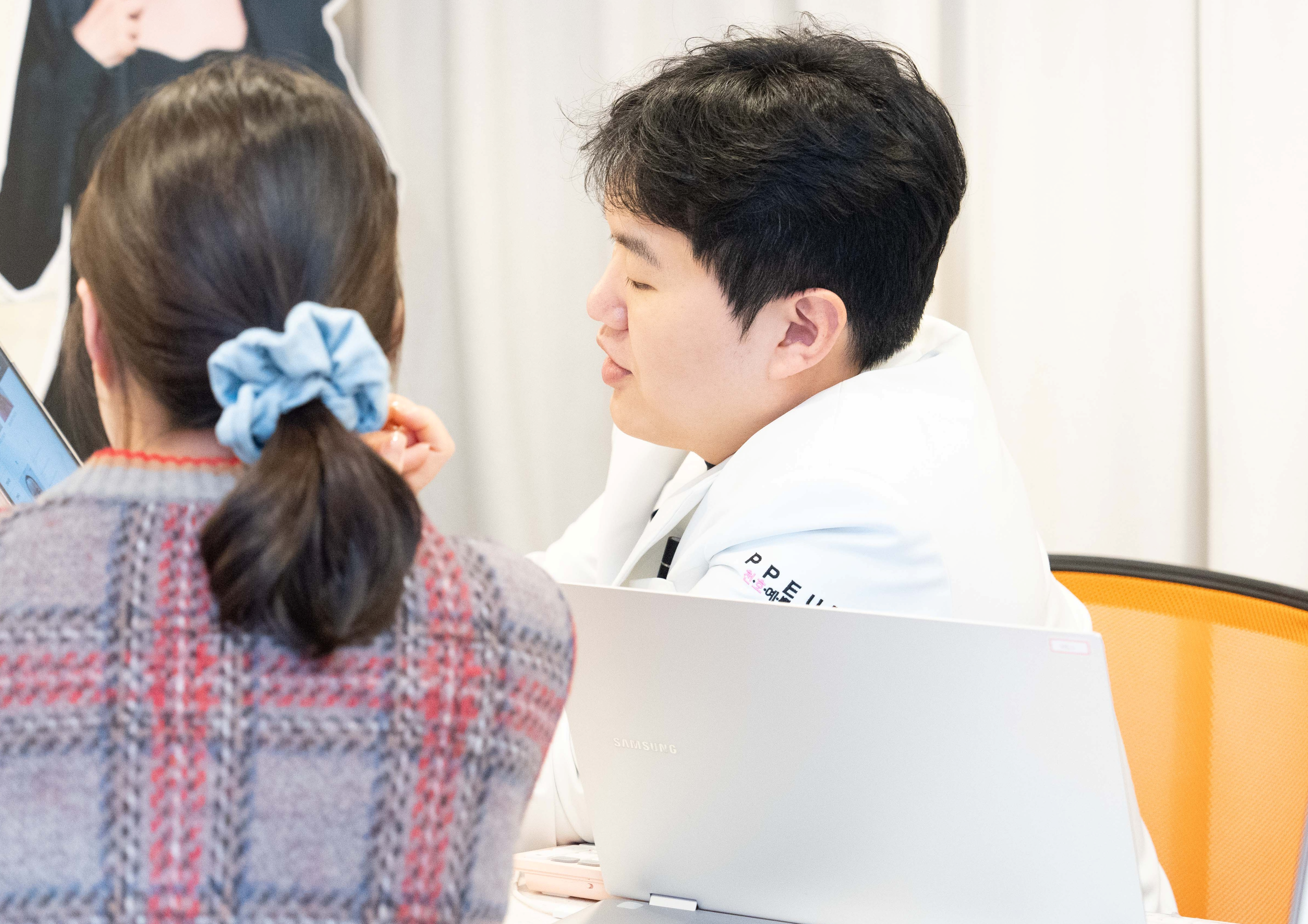 유앤아이의원 천호점 이태민 원장이 환자와 기미 치료 계획을 상담하는 모습