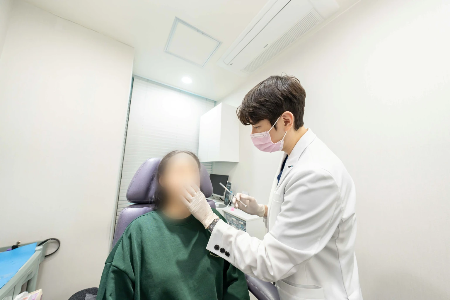 마곡 유앤아이의원 의료진이 환자의 얼굴을 살펴보며 시술을 진행하는 모습