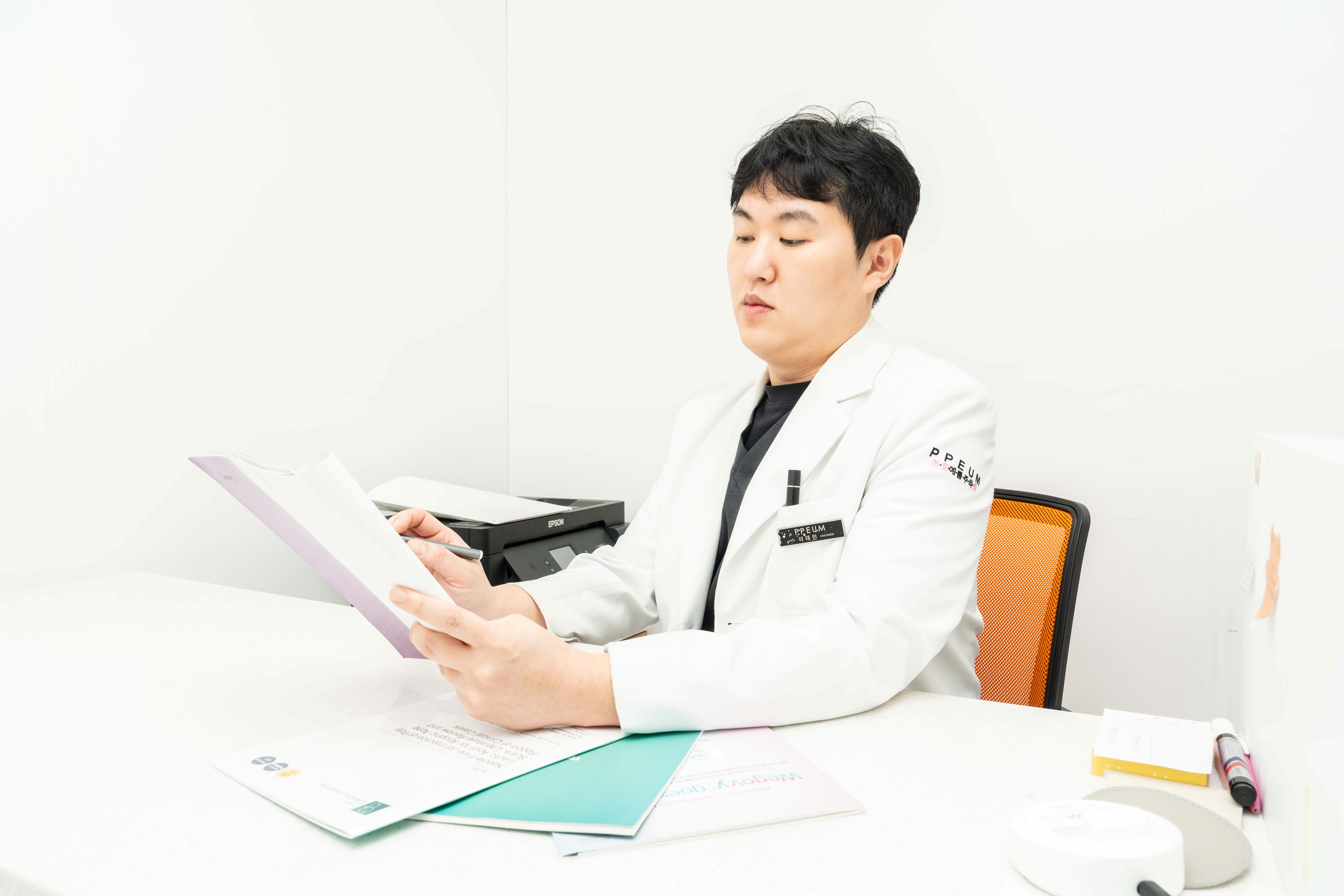 유앤아이의원 천호점 이태민 원장이 진료실에서 환자 진료 자료를 검토하는 모습