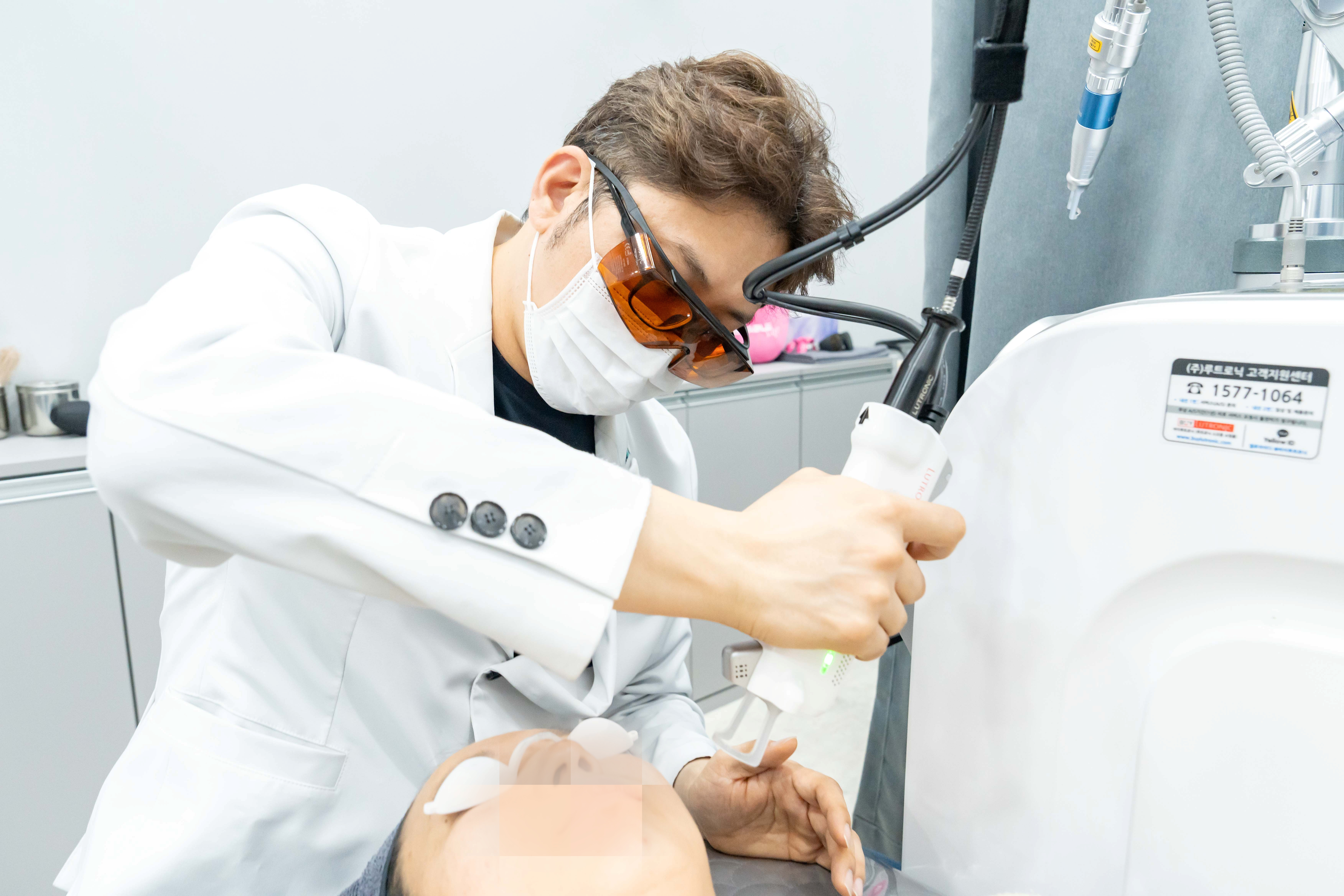 유앤아이의원 대전점 김병찬 원장이 클라리티2 레이저로 환자의 얼굴 부위를 시술하는 모습