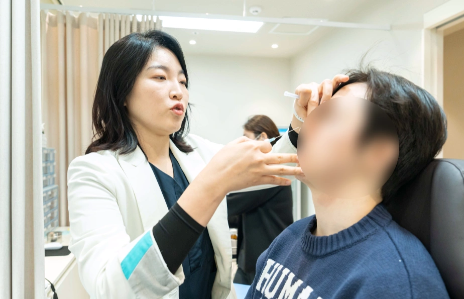 광교 유앤아이의원 최은진 대표원장이 환자의 20대 눈밑꺼짐 상태를 확인하고 필러 시술을 진행하는 모습