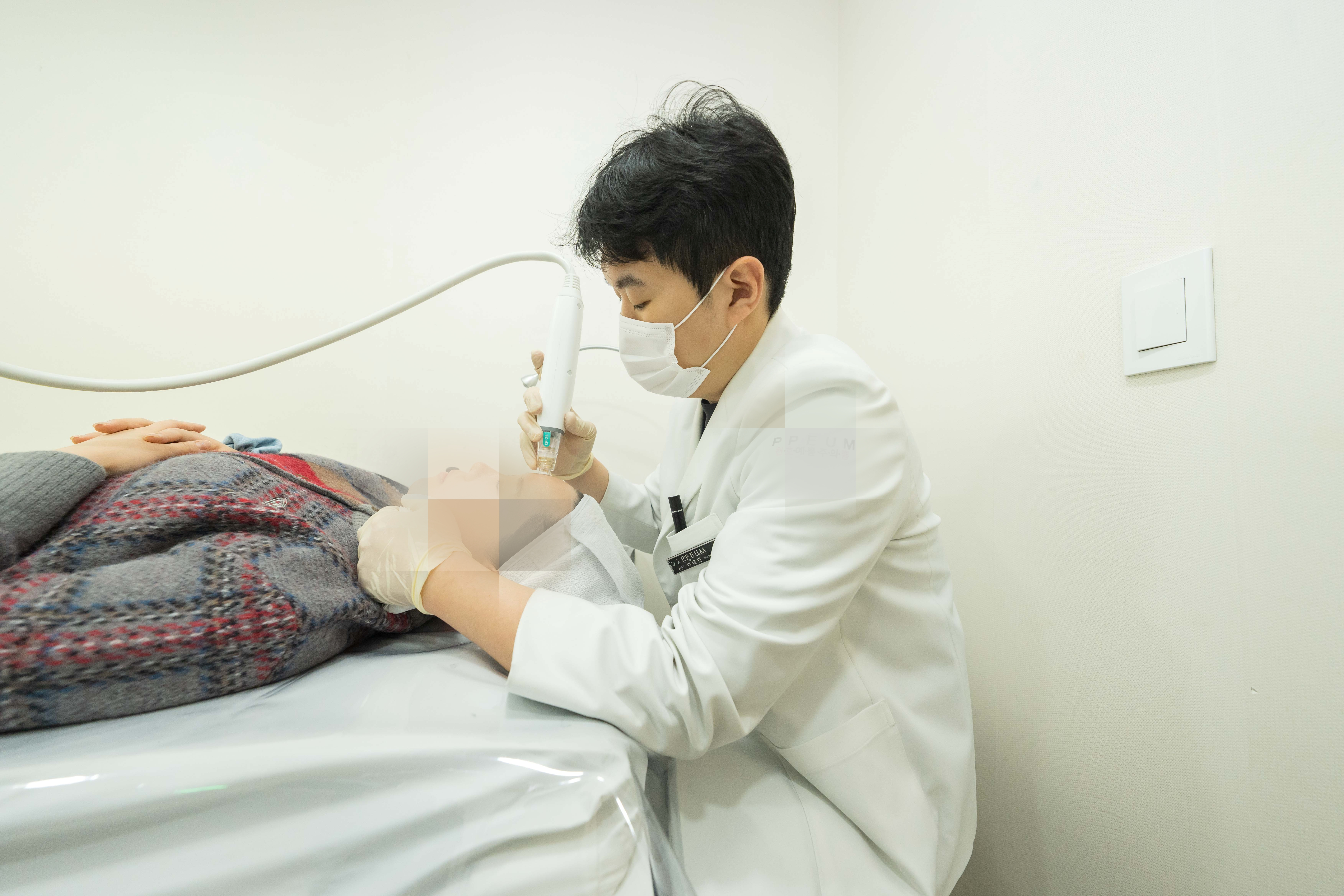 유앤아이의원 천호점 이태민 원장이 포텐자 장비를 이용해 환자의 이마 부위에 고주파 시술을 진행하는 모습