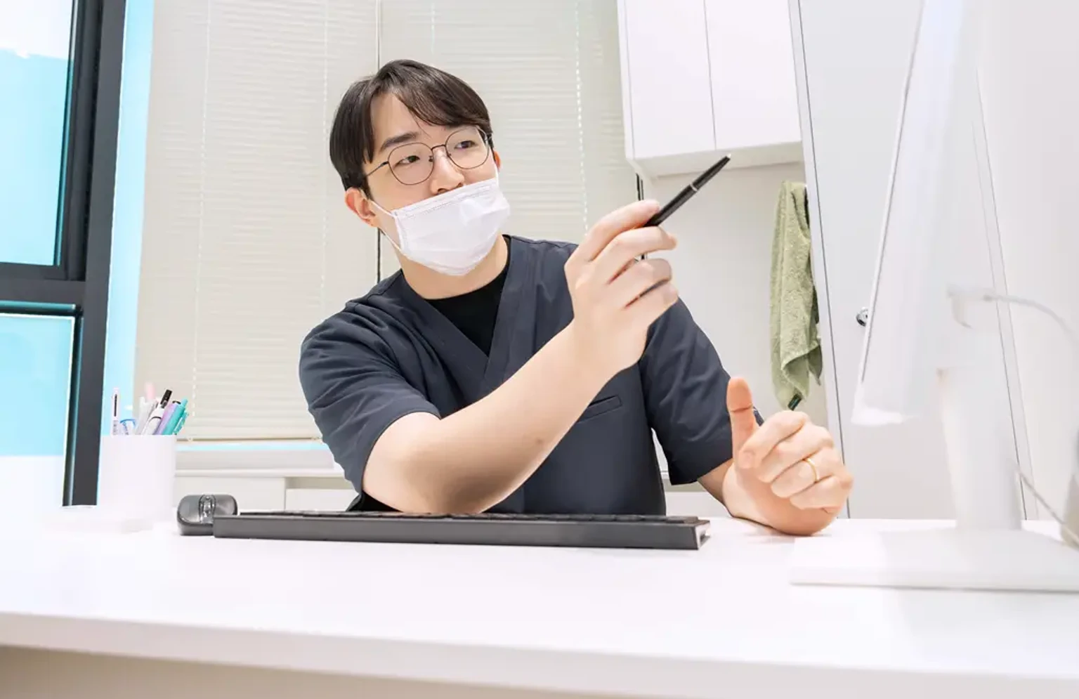피부과 진료실에서 의료진이 컴퓨터 모니터를 확인하며 피부 상태와 치료 방향을 검토하는 모습