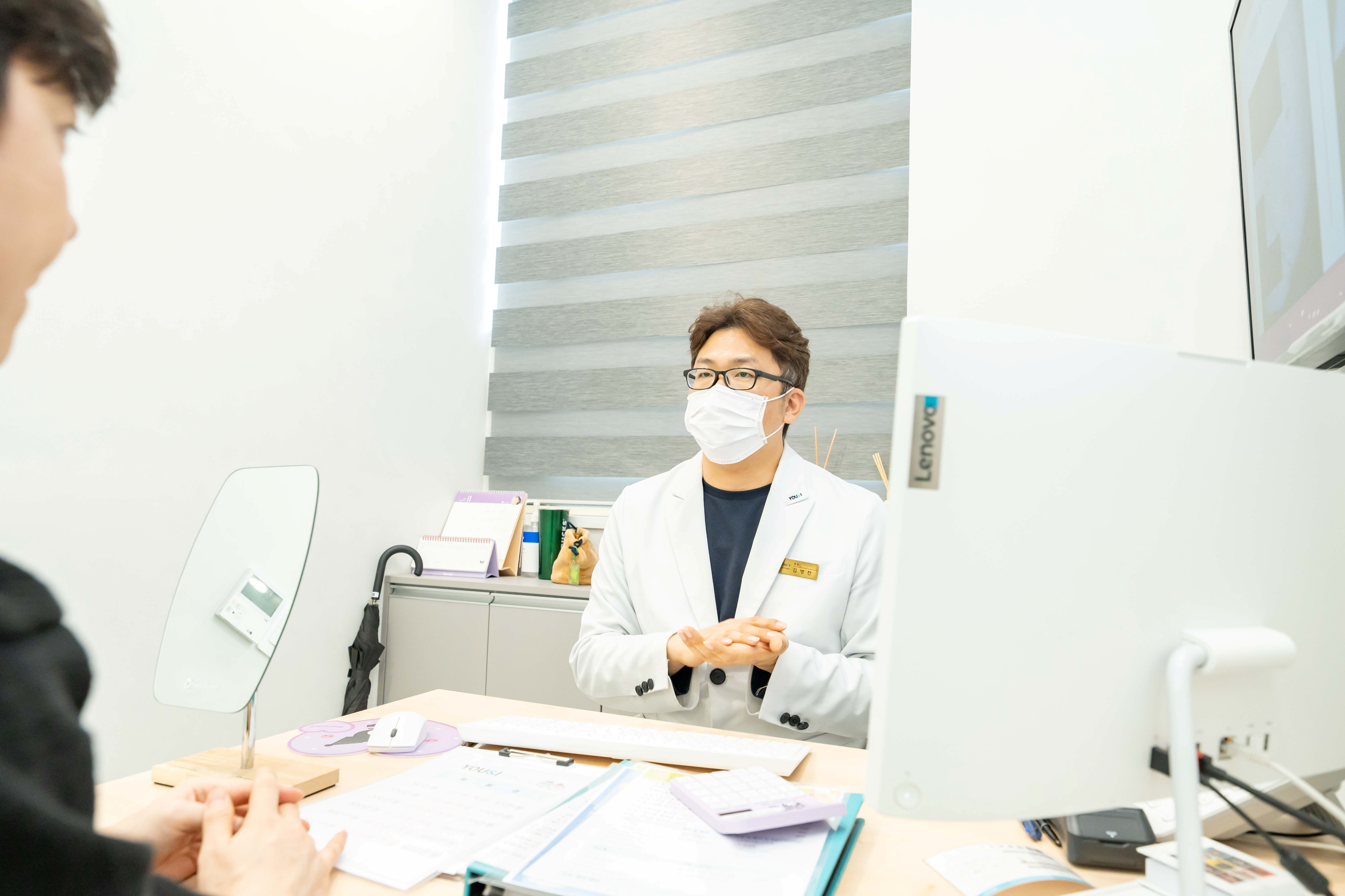 유앤아이의원 대전점 김병찬 원장이 진료실에서 환자와 피부 상태 및 치료 방향을 상담하는 장면