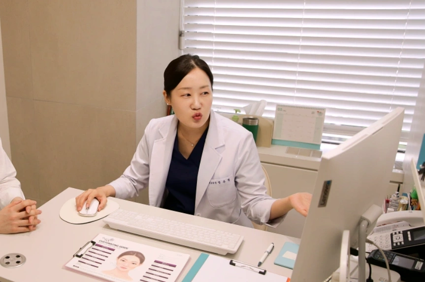 대구 유앤아이의원 장은영 대표원장이 진료실에서 모니터를 보며 환자에게 피부 상태를 설명하는 사진