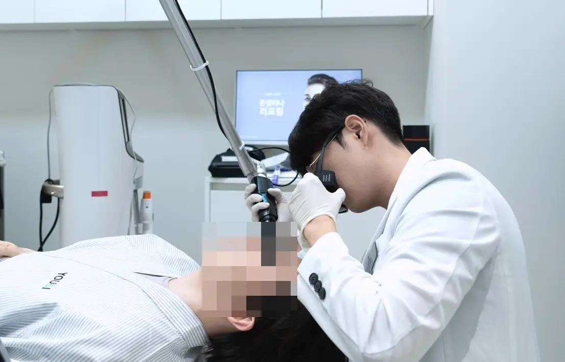 유앤아이의원 안양점에서 의료진이 환자의 기미 색소 병변을 확인하며 정밀 레이저 토닝 시술을 진행하는 모습