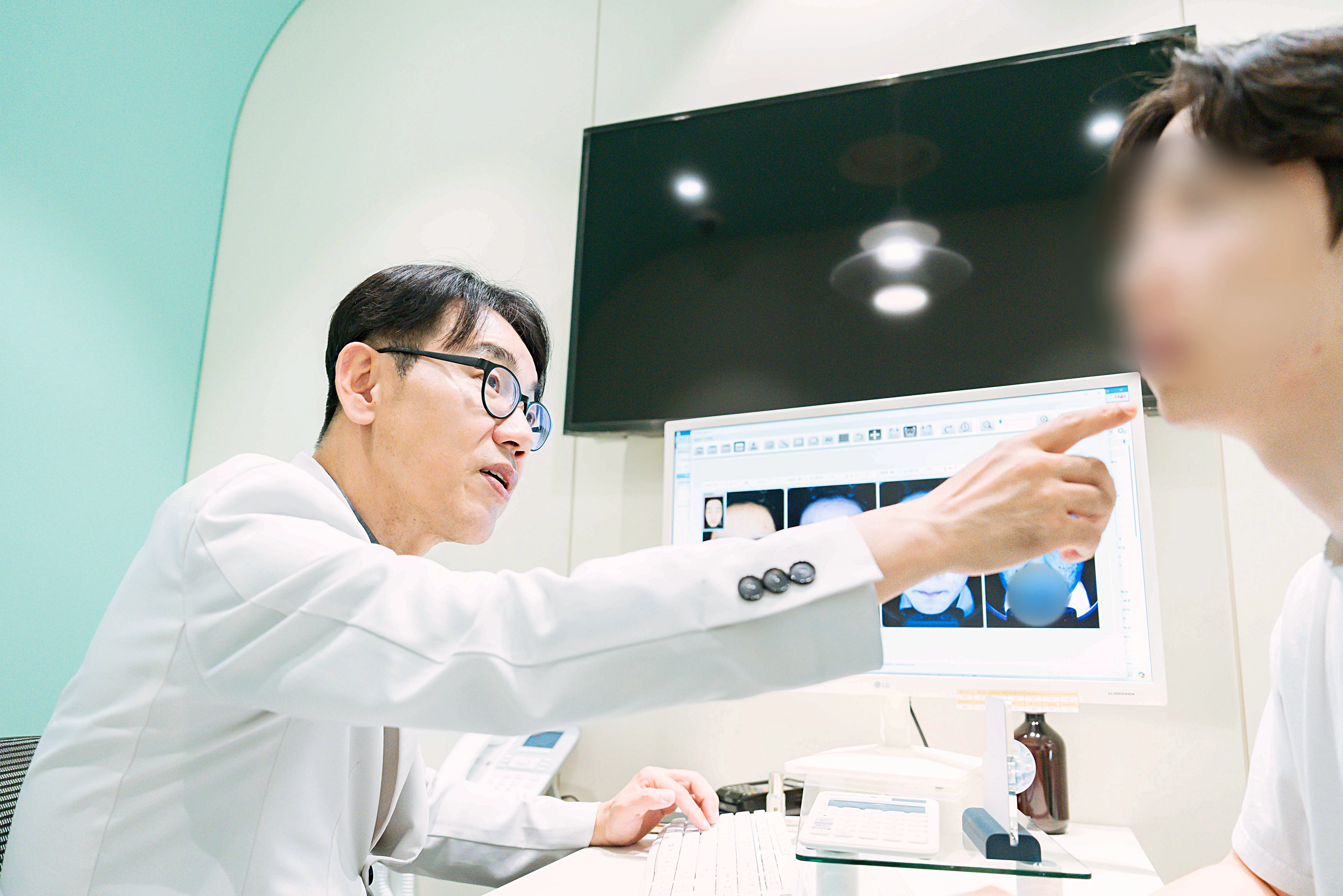인천검단-유앤아이의원 김선중 대표원장이 보톡스 시술 전 근육의 움직임과 얼굴 구조를 살펴보고 있는 모습