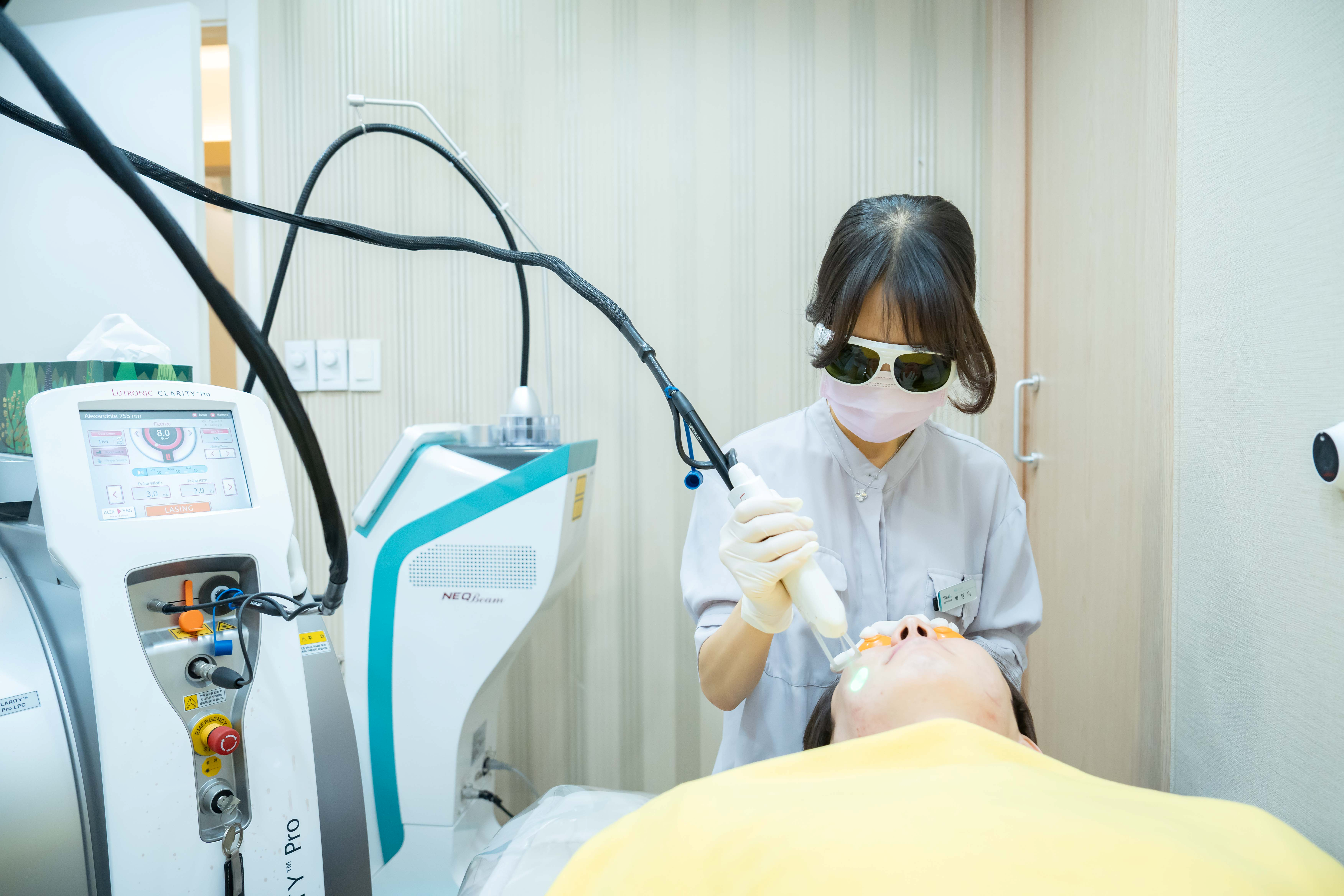 유앤아이의원 선릉점 의료진이 클라리티 프로 레이저 장비의 핸드피스로 레이저제모 시술하는 모습