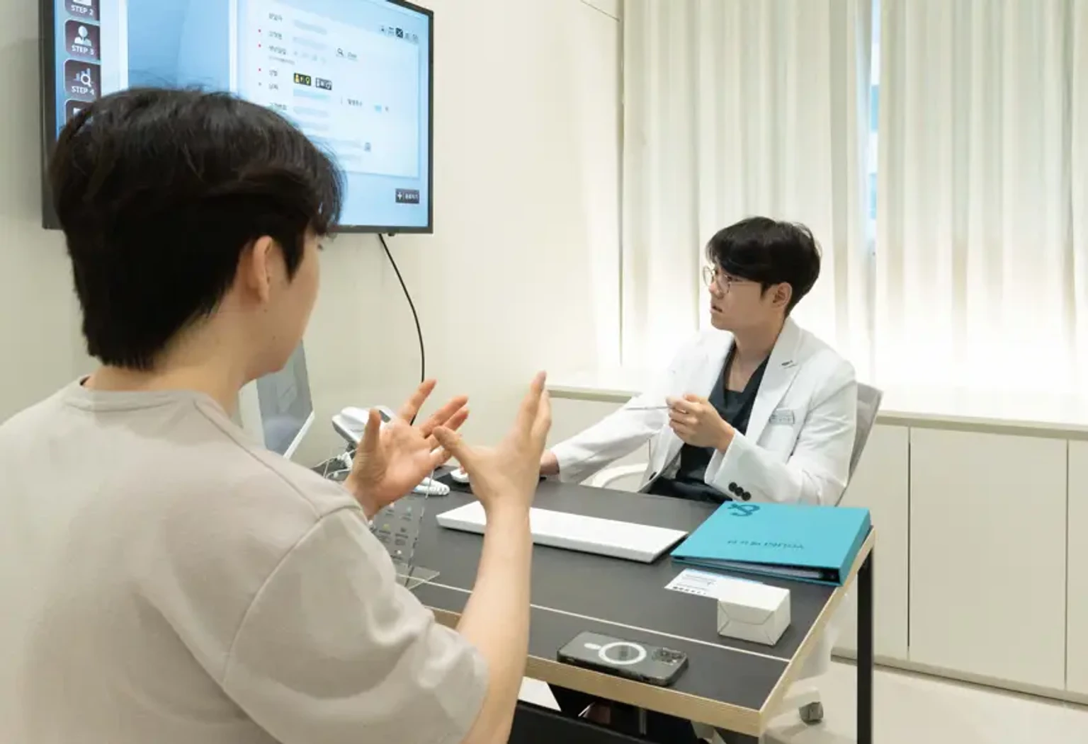 안양 진료실에서 피부 상태와 팔자주름 개선 방법을 상담하는 모습