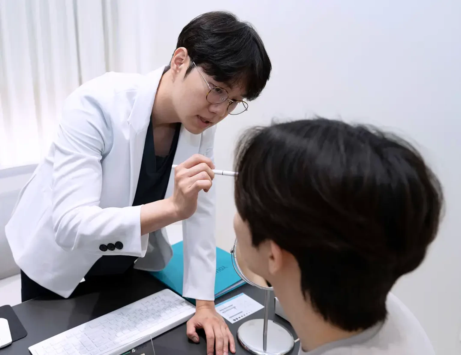 안양 진료실에서 흰 가운을 입은 김현준 원장이 진료를 보는 모습